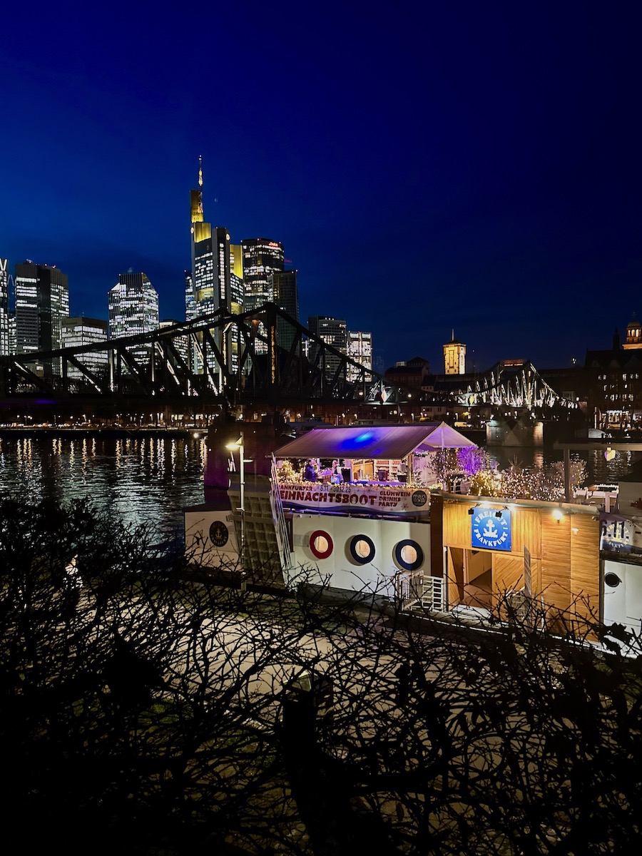 Frankfurt Weihnachtsmarkt: Blick auf die Skyline und den Eisernen Steg mit dem Boot Freigut davor